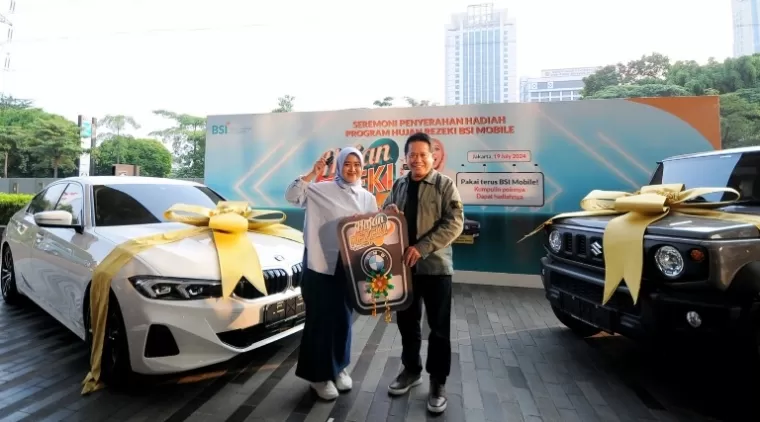 Direktur Utama BSI Hery Gunardi (kanan) menyerahkan hadiah utama  1 (satu) unit mobil BMW 321i kepada nasabah BSI KCP Cianjur Cipanas 2 Siti Rahmawati (kiri) pada acara Seremoni Penyerahan Hadiah Hujan Rezeki BSI Mobile di The Tower Jakarta, Jumat (19/7).