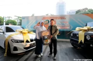Direktur Utama BSI Hery Gunardi (kanan) menyerahkan hadiah utama  1 (satu) unit mobil BMW 321i kepada nasabah BSI KCP Cianjur Cipanas 2 Siti Rahmawati (kiri) pada acara Seremoni Penyerahan Hadiah Hujan Rezeki BSI Mobile di The Tower Jakarta, Jumat (19/7).