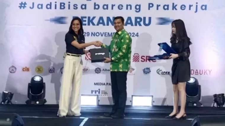 Direktur Kemitraan, Komunikasi dan Pengembangan Ekosistem PMO Prakerja, Dwina M Putri bersama Kepala Dinas Tenaga Kerja dan Transmigrasi (Kadisnakertrans) Provinsi Riau, Boby Rachmat saat menyerahkan pelakat penghargaan