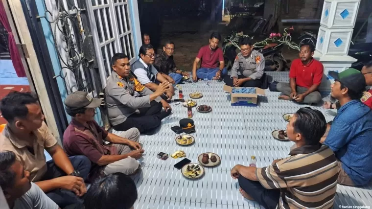 Malam - malam, Kapolsek Bangko Pusako Iptu Awi Ruben menemui warga dan menggaungkan pesan-pesan Pilkada Damai. (Afrius)