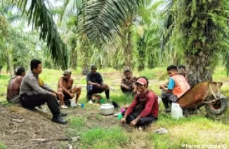 Bhabinkamtibmas Bangko Kanan, Aipda M. Rifai saat berdiskusi terkait Pilkada Damai dengan petani sawit, Jumat (13/9/2024). (Afrius)