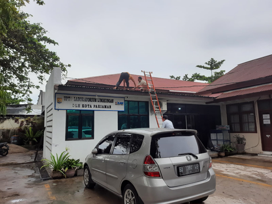 Beberapa petugas UPTD  Labling LH bekerja memperbaiki atap kantor yang bocor akibat hujan lebat dan angin kencang kemarin.