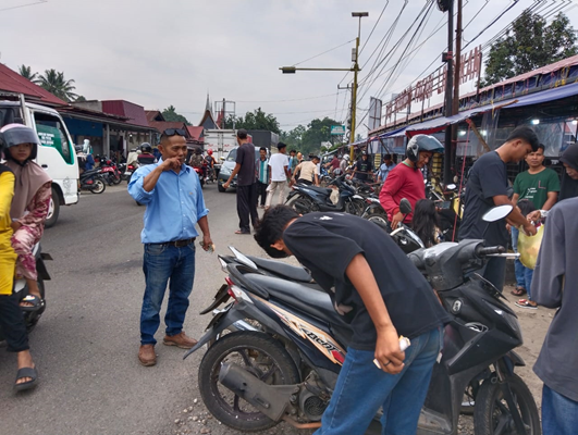 Misranhadi-Juru parkir di areal pasar pabukoan kelurahan Limbukan sedang mengatur kebdaraan yang hendak parkir.