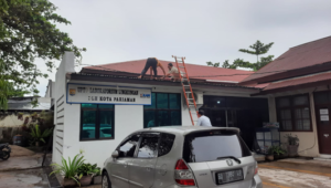 Beberapa petugas UPTD  Labling LH bekerja memperbaiki atap kantor yang bocor akibat hujan lebat dan angin kencang kemarin.