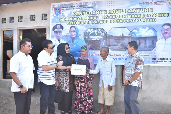 Pj Walikota Payakumbuh Jasman didampingi IJP saat mengucapkan selamat kepada M.Yusuf yang telah memiliki rumah layak huni.