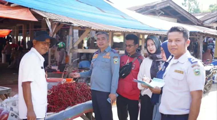 Koordinator Tim Satgas Pangan Kab. Solok ke Pasar Talang, Muhammad Djoni (tengah) dan Anggota Tim, saat memantau harga bahan pokok di Pasar Talang.