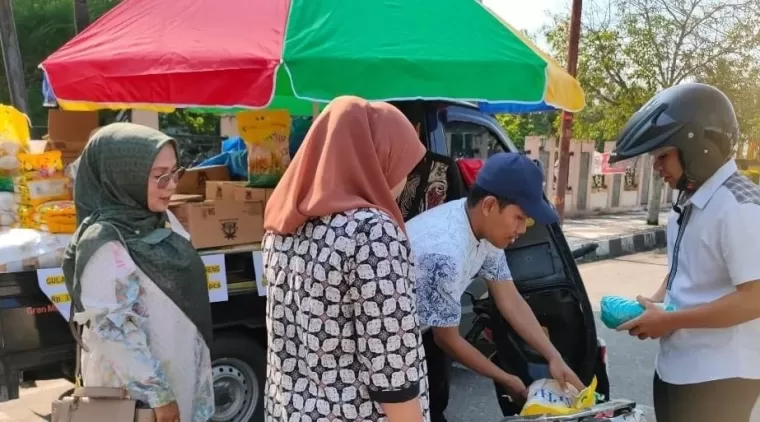 Masyarakat membeli minyak goreng dan gula pasir yang harganya terjangkau, saat Dinas Pangan Kota Solok menggelar Gerakan Pangan Murah.