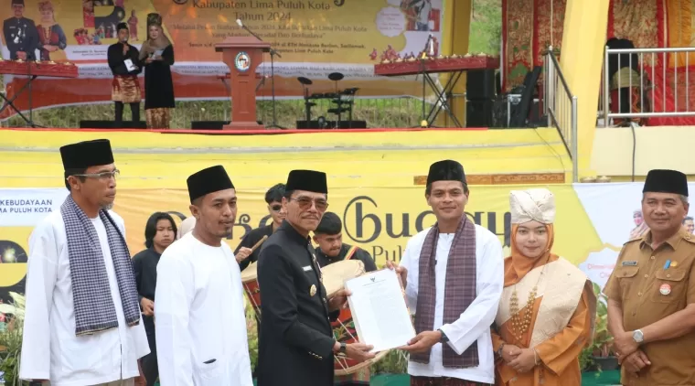 Kepala DPMD Sumatera Barat Amasrul selaku ketua tim penilai kepada bupati Limapuluh Kota Safarudddin Dt. Bandaro bersamaan pada pembukaan Pekan Budaya di RTH Mahkota Berlian, Senin 1 Juli 2024