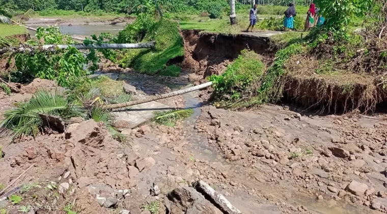 kondisi jalan rabat beton yang putus dihondoh banjir.