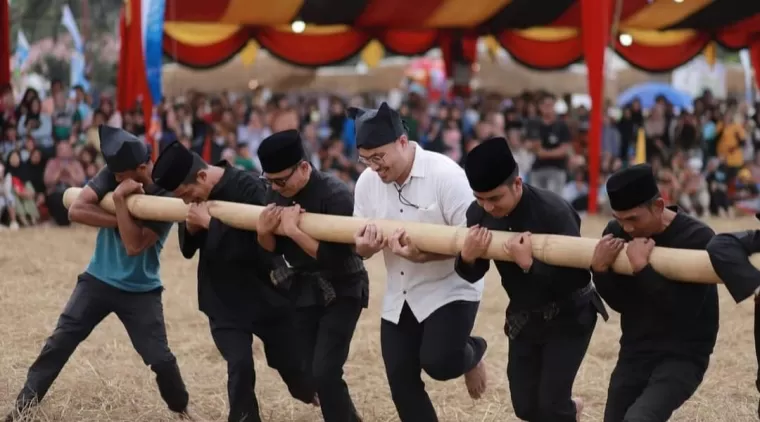 Wawako RamadhanI Kirana Putra (2 kanan) bersama warga lainnya, saat ikut permainan tradisional Batuang Gilo.