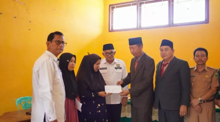 Staf Ahli Bupati, Safrudin didampingi Ketua Baznas,H.Edwar dan Pejabat lainnya, menyerahkan bantuan kepada salah seorang keluarga korban longsor tambang emas Sungai Abu