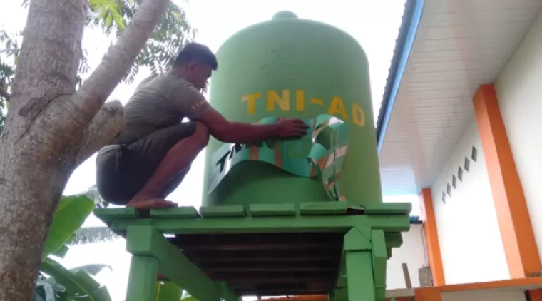 Pengecatan Tandon Air Oleh Satgas TMMD 122 Di Desa Limbu Sedulun