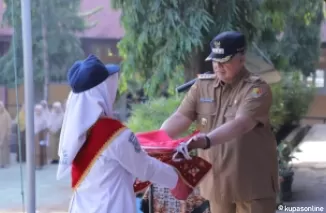 Wako Zul Elfian Umar menyerahkan bendera merah putih kepada salah seorang petugas, untuk dikibarkan pada pelaksanaan Upacara Bendera di SMPN 6 Kota Solok.