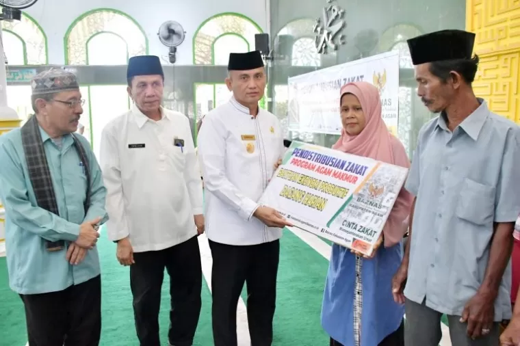 Pjs Bupati Agam, Dr. Endrizal, SE, M.Si menyerahkan program zakat, infak dan sedekah (ZIS) dari Badan Amil Zakat Nasional (Baznas) Kabupaten Agam