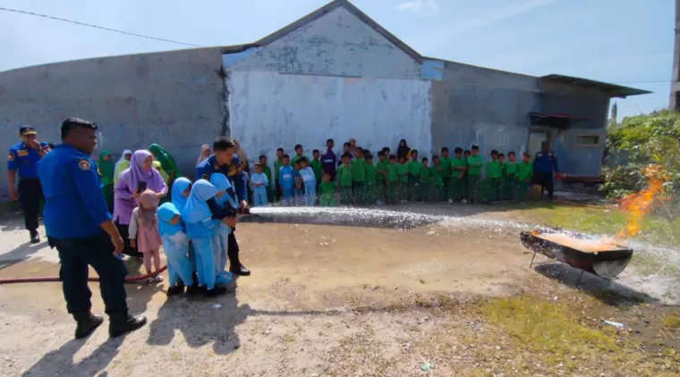 Murid  TK Islam terpadu dan SD khalifatul fajar Kota Pariaman sedang menerima pembelajaran cara memadamkan api dibimbing petugas Damkar.(Trisnaldi).