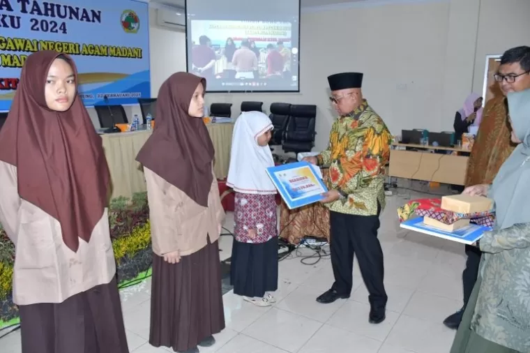 Sekdakab Agam, Drs. Edi Busti, M.Si, secara simbolis menyerahkan hadiah kepada siswa dan mahasiswa berprestasi