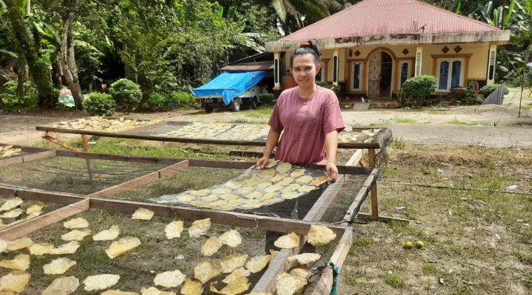 Pelaku usaha Kerupuk Jengkol Nanda di Paraman, sedang membalikan kerupuk jengkol yang sedang dijemir mata hari.(Trisnaldi).