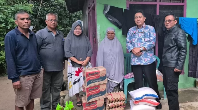 Kepala Dinas Sosial Kabupaten Solok,Mulyadi Marcos (2 kanan) menyerahkan bantuan kepada masyarakat korban banjir.