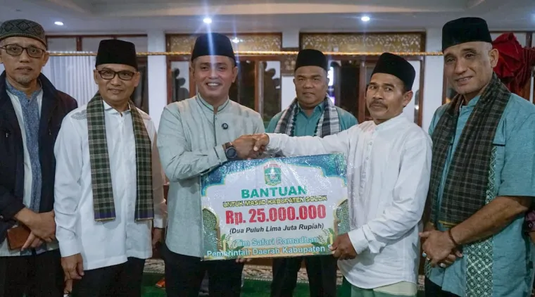 Bupati Jon Firman Pandu (tengah) menyerahkan bantuan uang kepada Pengurus Masjid Darul Qarar Lubuk Selasiah (2 kanan).