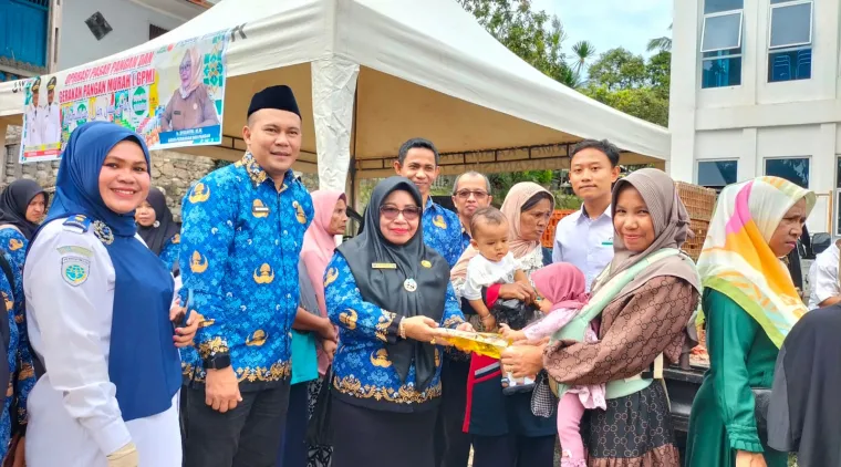 Kadis Perikanan dan Pangan, Ir.Syoufitri,MM, (tengah),bersama masyarakat pembeli di kegiatan Operasi Pasar di halaman Kantor Camat Gunung Talang.