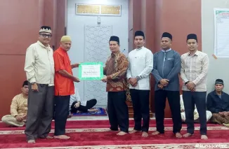 Sekretaris Tim XV, Irsyad, secara simbolis menyerahkan bantuan uang kepada pengurus Masjid Nurul Hidayah Banda Panduang (2 kiri), disaksikan Ketua Tim XV Zulfadli (kiri) Wakil Ketua Tim XV, Romi Indra Utama dan anggota Tim XV lainnya.