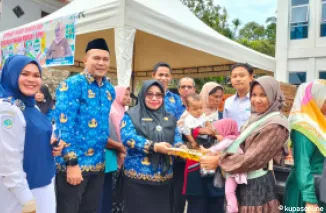 Kadis Perikanan dan Pangan, Ir.Syoufitri,MM, (tengah),bersama masyarakat pembeli di kegiatan Operasi Pasar di halaman Kantor Camat Gunung Talang.