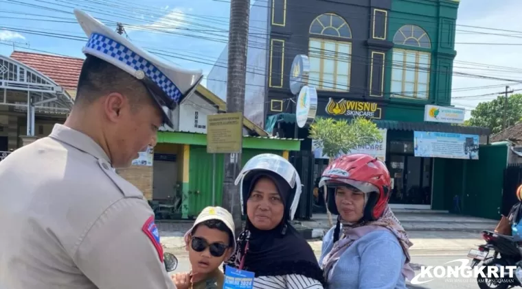 Personel Unit Kamsel Satlantas Polres Tulungagung saat membagikan pamflet kepada salah satu warga pengguna jalan