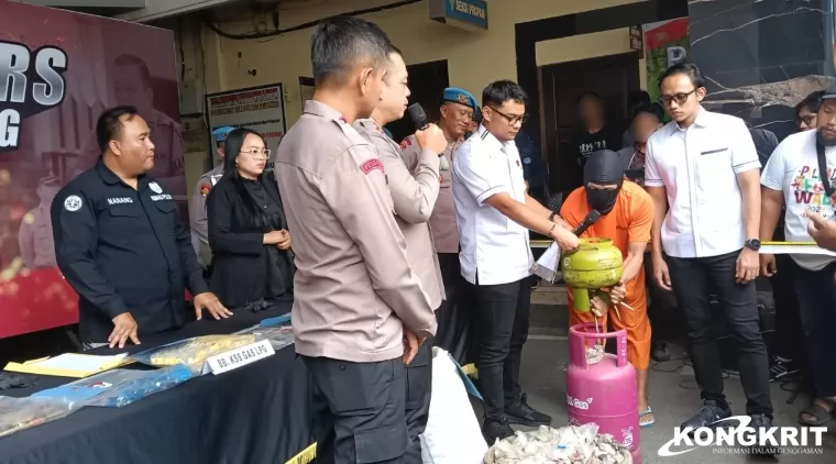 Tersangka AT saat mempraktekkan cara pengisian gas LPG dari tabung 3 kg ke tabung 12 kg.