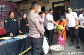 Tersangka AT saat mempraktekkan cara pengisian gas LPG dari tabung 3 kg ke tabung 12 kg.