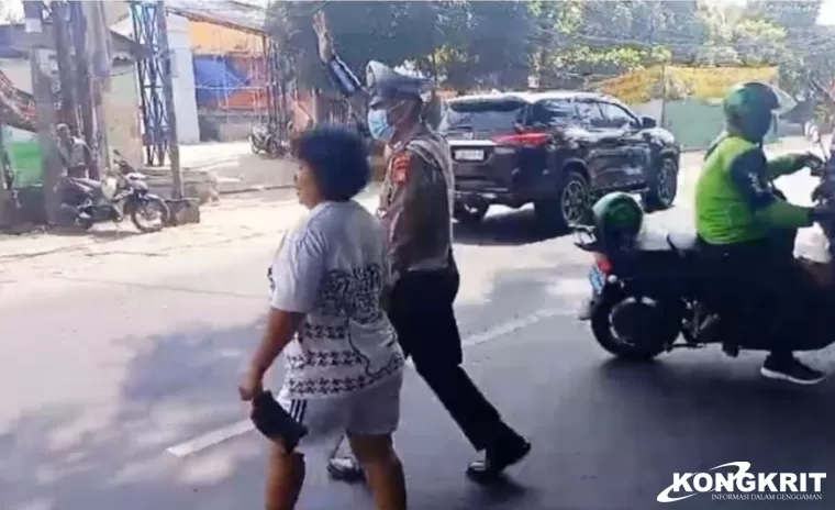 Anggota Lantas Polsek Bantar Gebang Bantu Warga Menyeberang Jalan di Depan Pasar