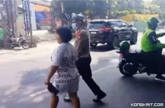 Anggota Lantas Polsek Bantar Gebang Bantu Warga Menyeberang Jalan di Depan Pasar