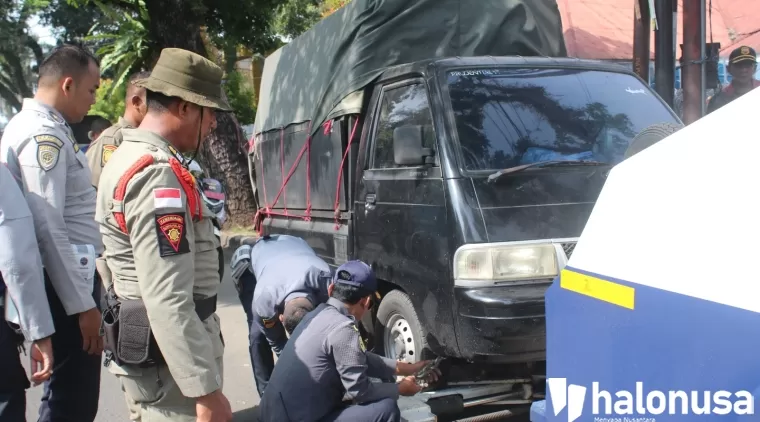 Tim Satpol PP Kota Padang bersama Dishub Padang menderek mobil toko yang ada di kawasan Jati