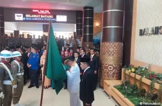 Hendri Septa mencium Bendera Petaka Pemko Padang sebagai tanda berpamitan. (Foto: Istimewa)