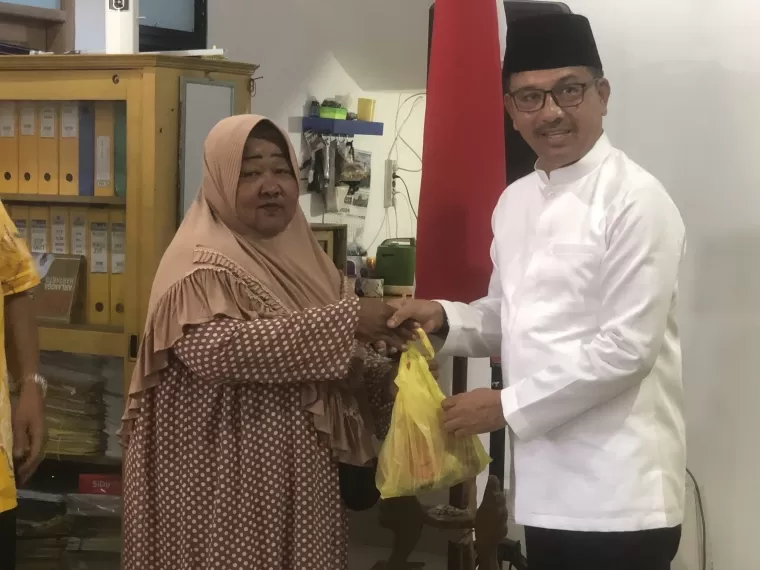 Ketua DPD Golkar Sumbar, Khairunas memberikan daging kepada salah seorang warga.