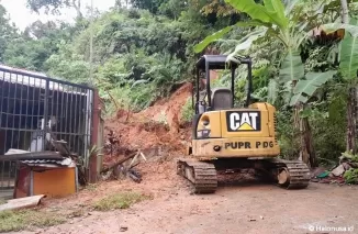 Alat berat dari Dinas PUPR Kota Padang membersihkan material longsor