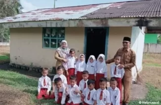 Kepala Sekolah, guru dan siswa berfoto di depan gedung bangunan bekas WC yang dijadikan ruang kelas (Foto: SDN 002)