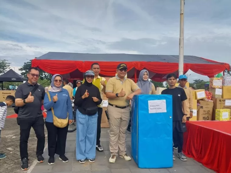 Pj Wali Kota Padang memperlihatkan berbagai hadiah untuk peserta senam dalam peringatan Hari Koperasi Nasional ke-77.