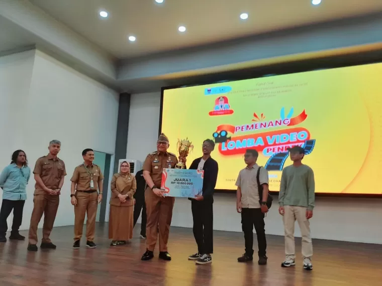 Pj Wali Kota Padang menyerahkan piala kepada pemenang lomba video pendek