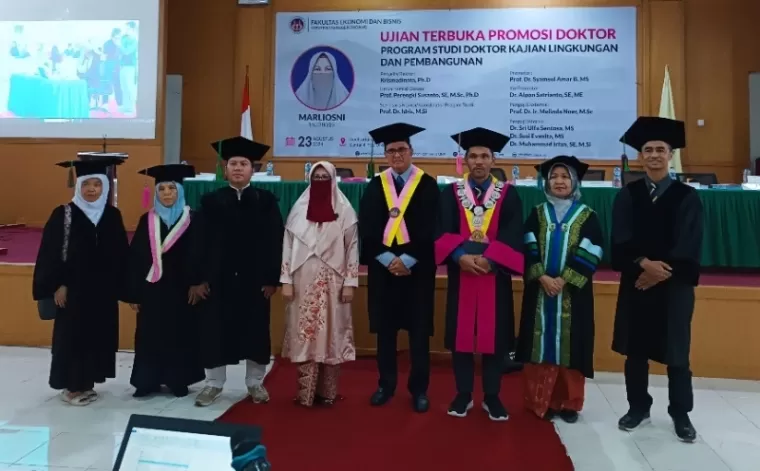 Marliosni (60) bersama Dekan FEB UNP, Promotor dan Penguji usai lulus ujian terbuka promosi Doktor Prodi Kajian Lingkungan dan Pembangunan FEB UNP, Jumat (23/8/2024) di Aula Fakultas FEB UNP. (Foto: Dewi/Halonusa)