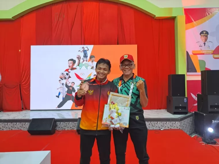 M. Fauzan Al Ghifari (kiri) bersama manager tim gulat Sumbar,Ilmarizal. (Foto: Istimewa)