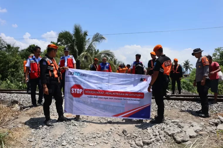 Petugas menutupi perlintasan sebidang liar Kereta Api di Padang. (Foto: Humas KAI Divre II Sumbar)