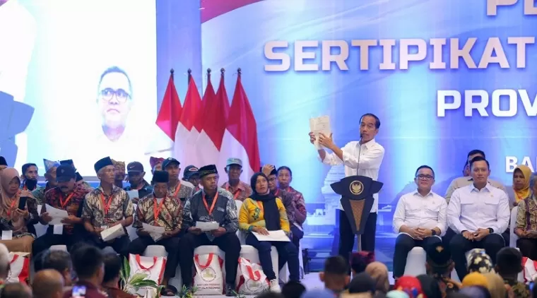 Presiden Joko Widodo (Jokowi) sedang memperlihatkan bentuk sertifikat elektronik kepada masyarakat