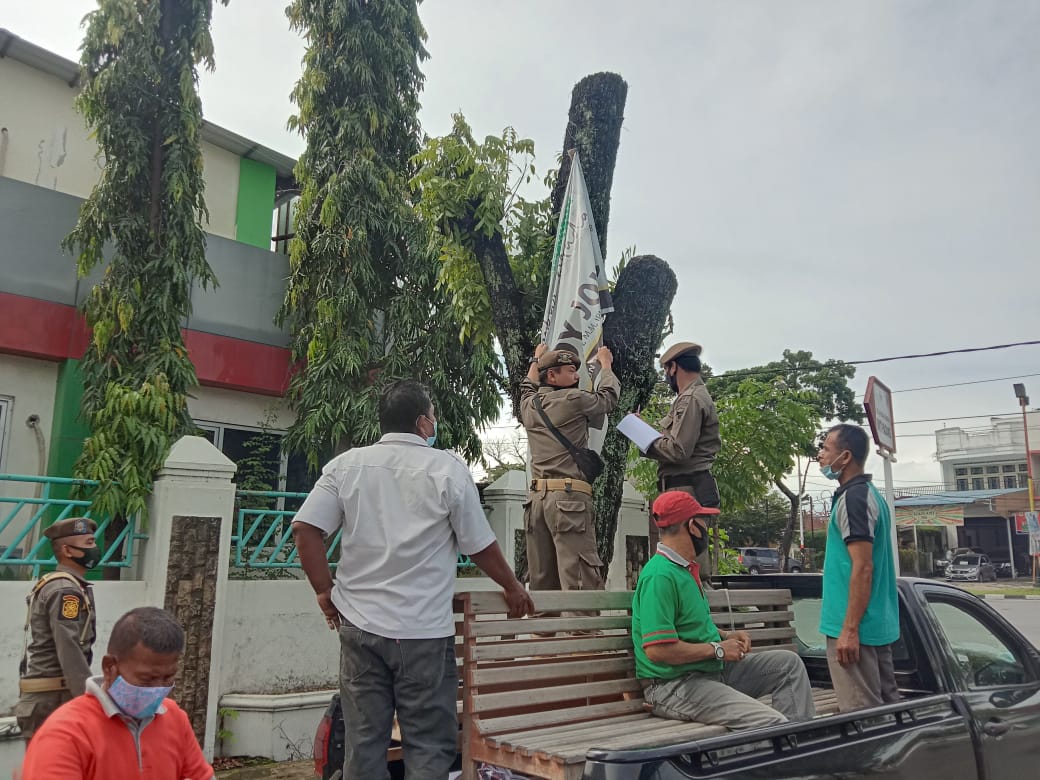 Anggota Satpol PP Kota Padang, Sumatera Barat mencopot APK calon kepala daerah dari pohon, Rabu (25/11/2020) | Gon/Halonusa