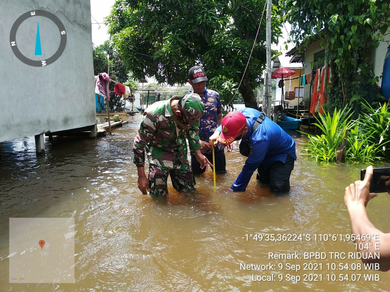 Petugas mengukur ketinggian air akibat banjir yang melanda dua kecamatan di Kabupaten Ketapang. (Foto: Dok. Istimewa)