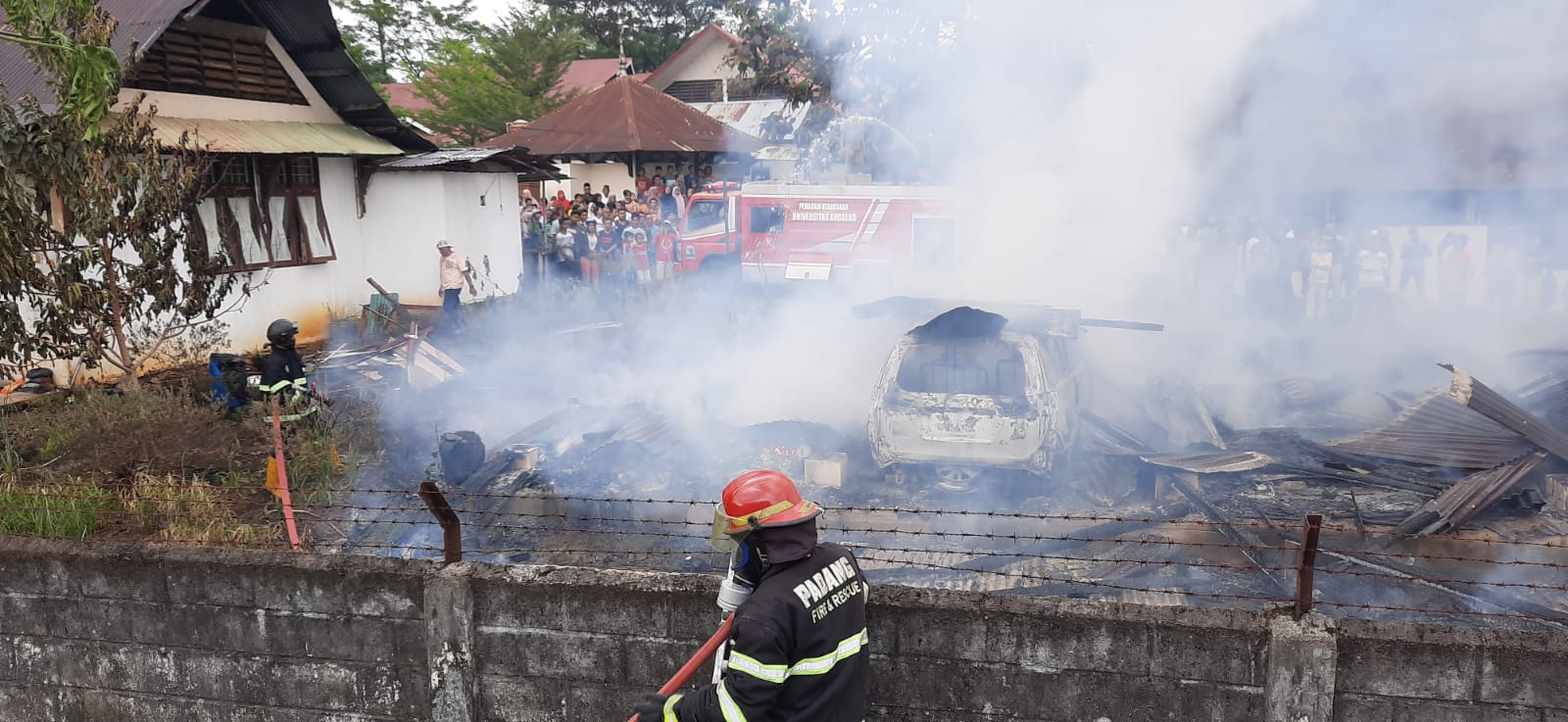 Petugas Damkar Kota Padang memadamkan api pada mobil yang terbakar di kampus UNP Limau Manis. (Foto: Dok. Damkar Kota Padang)