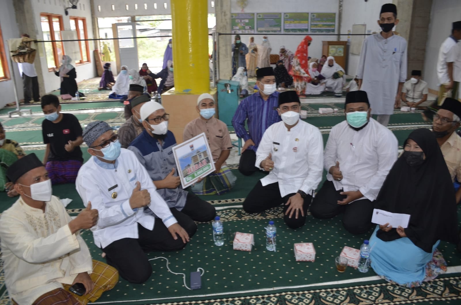 Wali Kota Padang, Hendri Septa didampingi Camat Lubuk Begalung, Heriza Syafani dan Kabag Kesra, Fuji Astomi memberikan bantuan dalam Program Jumat Berkah di Musala Nur Jannah. (Foto: Dok. Humas Kota Padang)