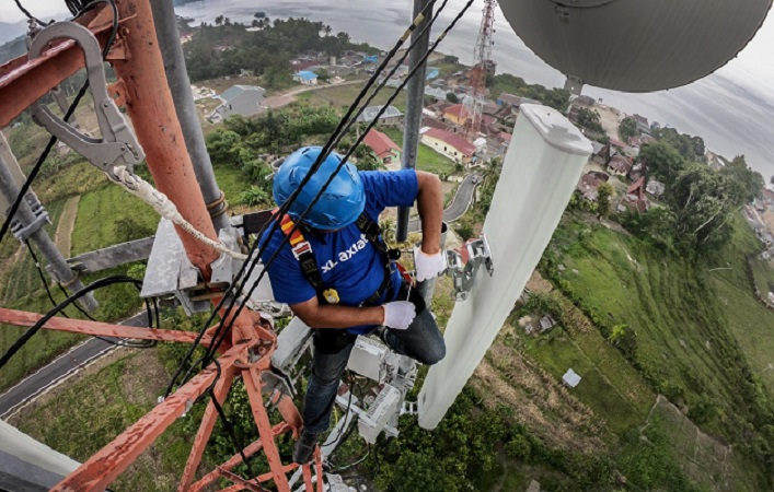 Teknisi XL Axiata melakukan pemeliharaan perangkat BTS di atas tower di sekitar kawasan wisata Danau Toba, Samosir, Sumatera Utara, beberapa waktu lalu. (Foto: Humas XL Axiata)