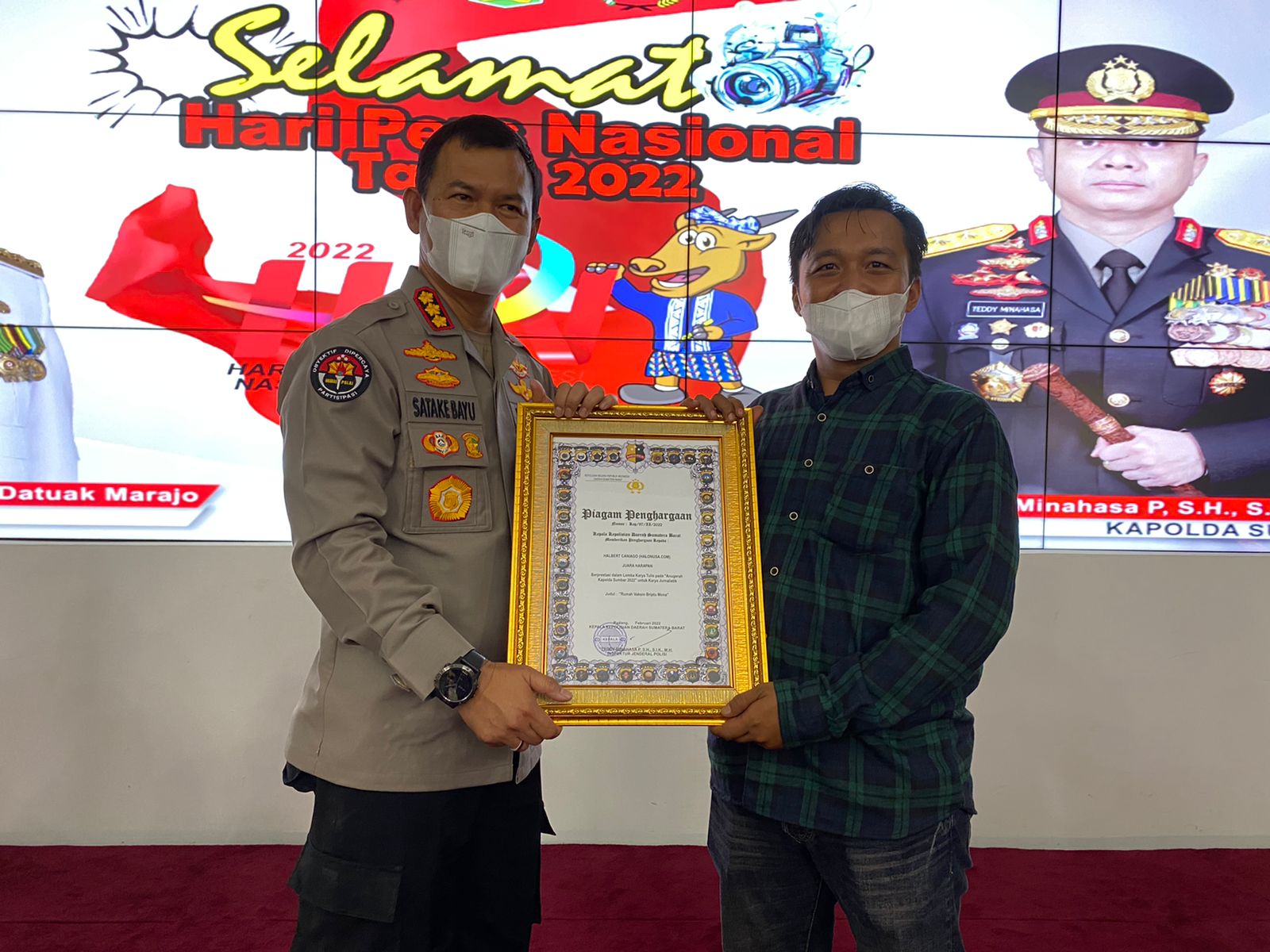 Menang Anugerah | Kabid Humas Polda Sumbar Kombes Pol Satake Bayu Setianto (kiri) menyerahkan plakat termasuk sertifikat kepada Jurnalis Halonusa Halbert Caniago (kanan) setelah memenangkan lomba Anugerah Jurnalistik Kapolda Sumbar dalam rangka HPN 2022 t