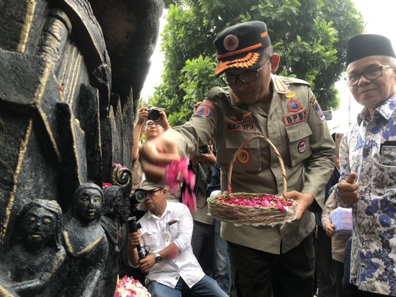 Wali Kota Padang menaburkan bunga sebagai tanda duka cita di Tugu Gempa Padang