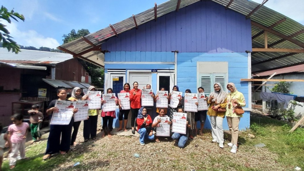 Elda Misdof selaku calon legisaltif (Caleg) dapil 4 nomor urut 3 berfoto bersama dengan masyarakat di Kelurahan Koto Baru Nan XX yang menerima bantuan bedah rumah. (Foto: Halonusa.com)